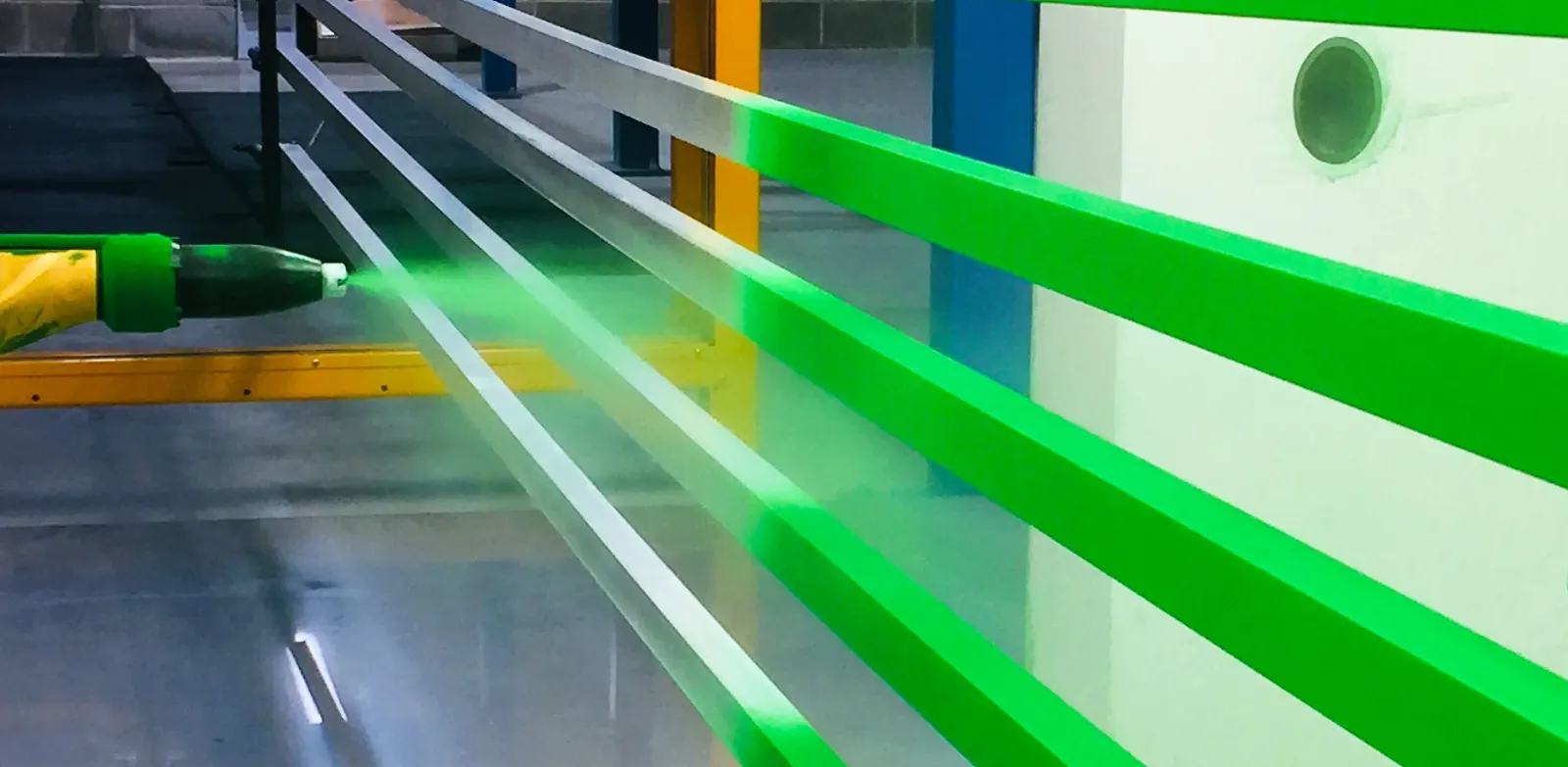 Green architectural aluminium extrusions moving through Swallow's powder coating line
