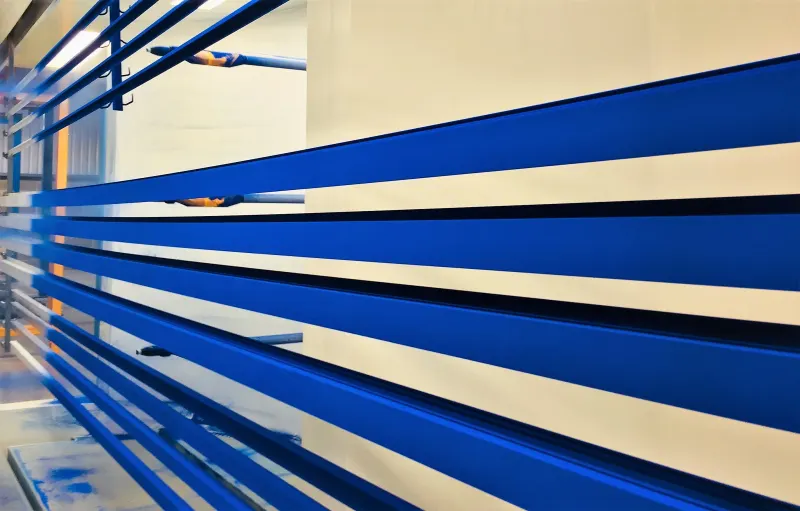 Blue coated aluminium profiles crossing the production line